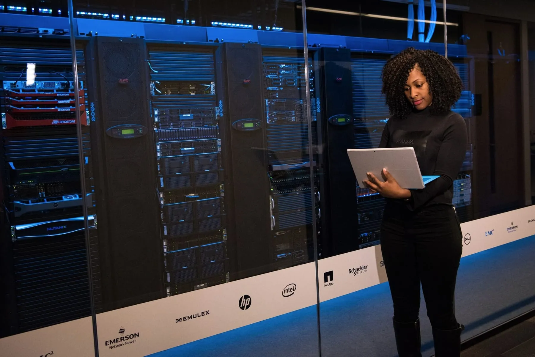 An engineer holding a laptop in a server room