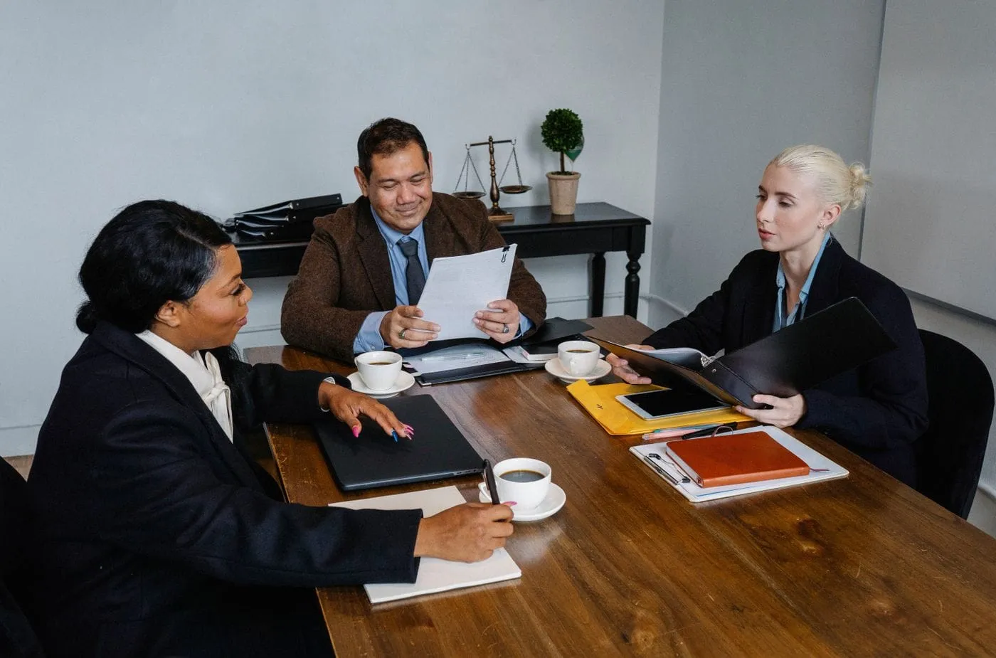Three colleagues reviewing documents together at a meeting table