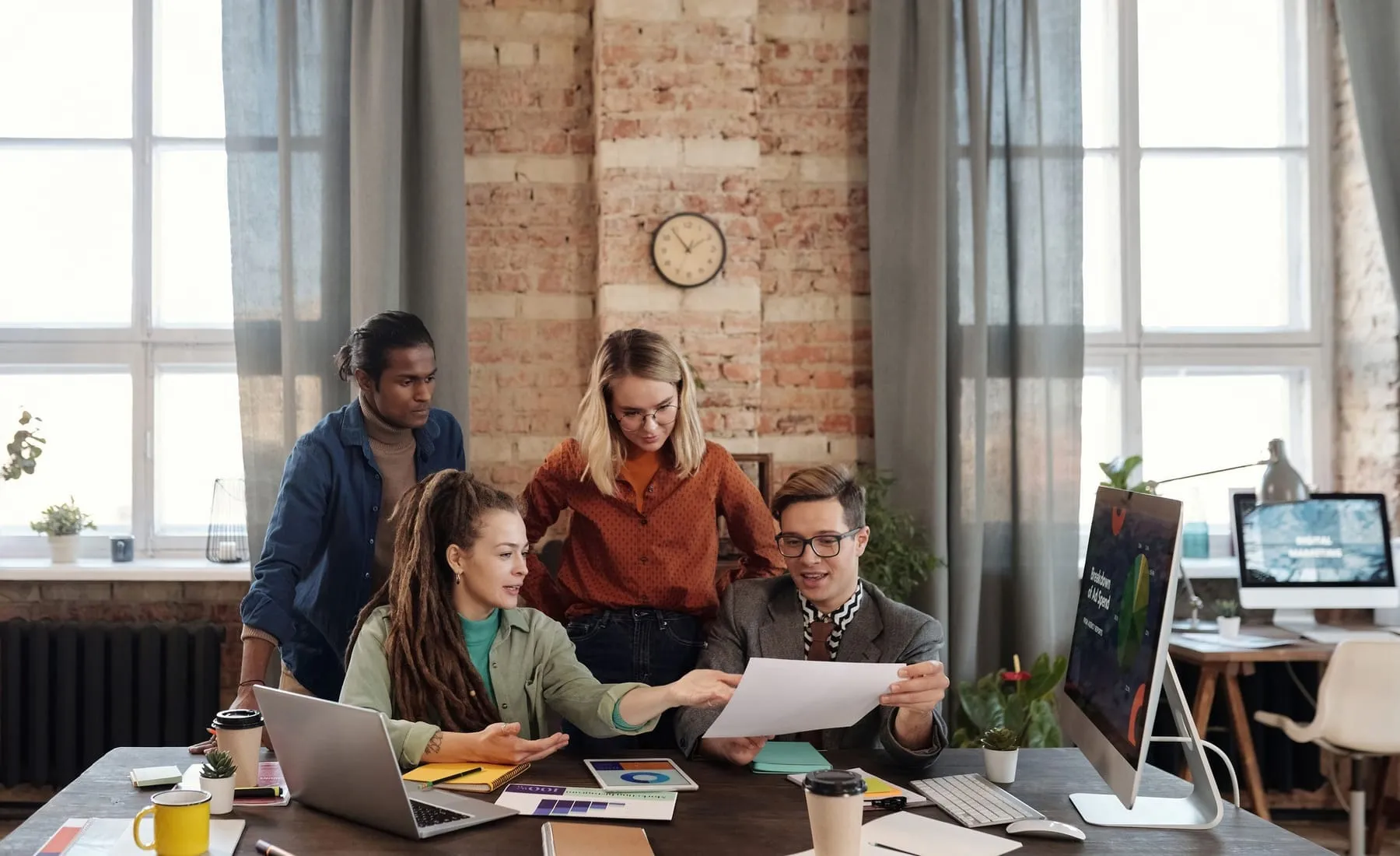 A small team working together around a table in a bright office